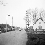 169406 Gezicht op de spoorwegovergang in de Nieuweweg te Hoogkarspel, met rechts wachterswoning nr. 35.